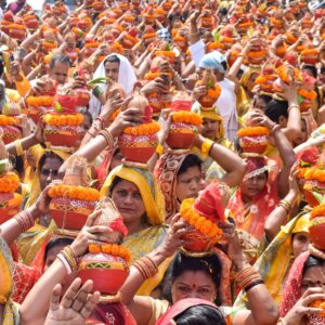 Colorful cultural ceremony featuring women carrying Kalash at a temple festival in India.